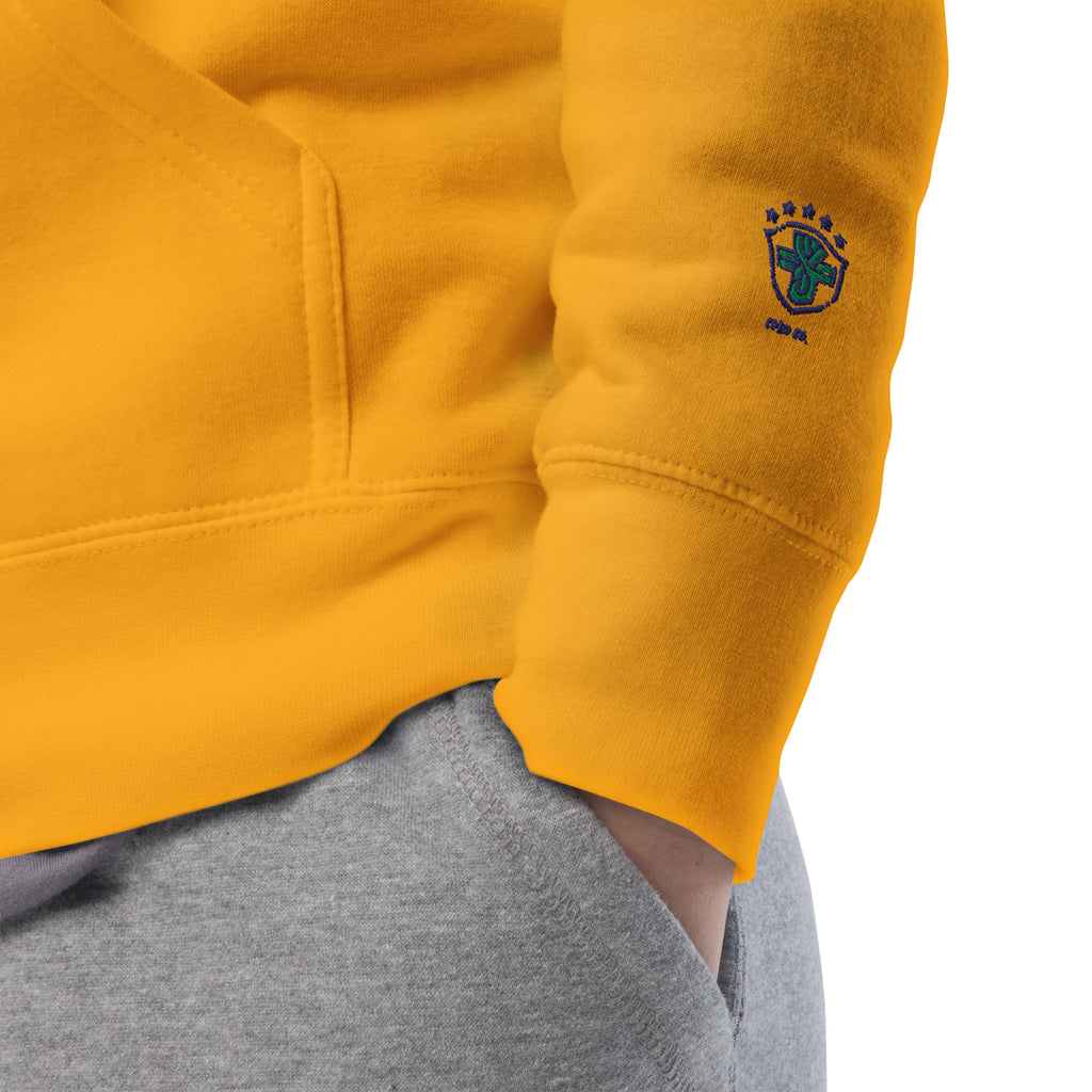 Close-up of the gold hoodie's cuff and blue-and-green sleeve emblem